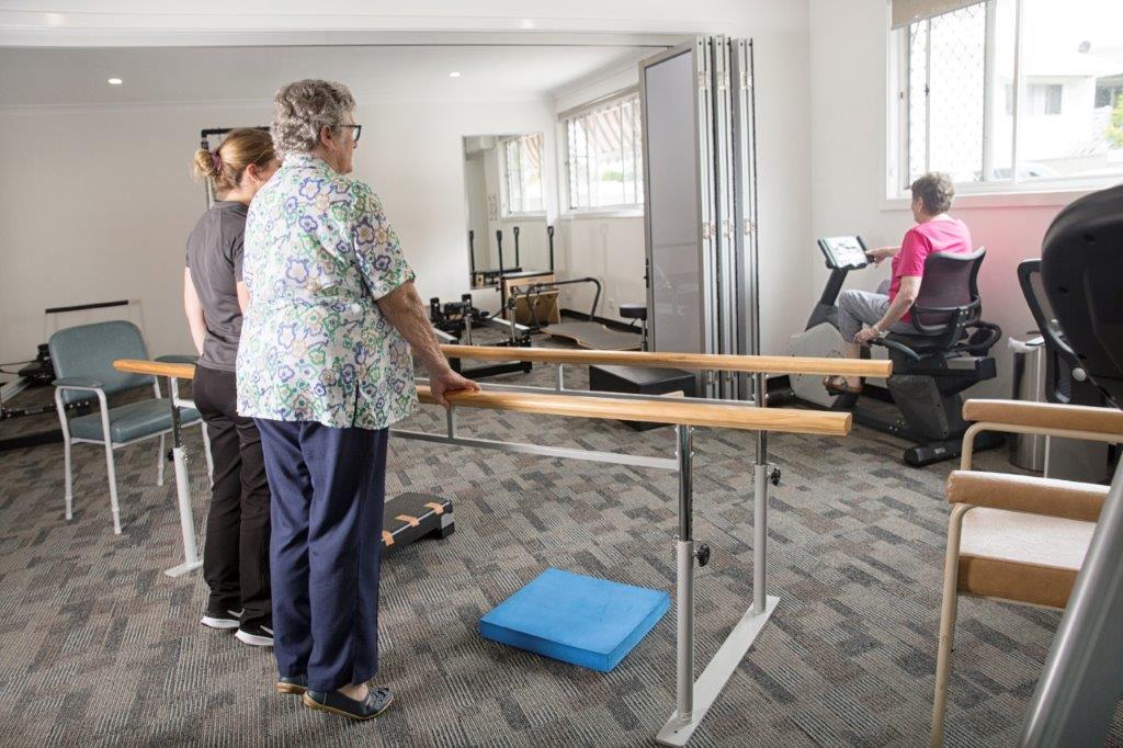 Two woman participating in a rehabilitation class guided by a therapist