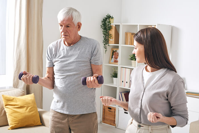 Man being taught rehabilitation exercises in his home